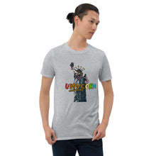 Load image into Gallery viewer, A man in his twenties wearing a grey t-shirt that says &quot;uNYCorn&quot; in various colors and has a cartoon depiction of the Statue of Liberty as a unicorn. The shirt is made by Real Unicorn Apparel.
