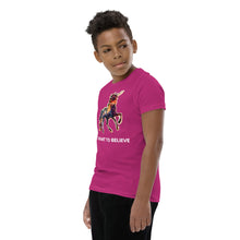 Load image into Gallery viewer, A Black youth wearing an &quot;I Want To Believe&quot; t-shirt from Real Unicorn Apparel. The shirt is in the berry color and has a beautiful, rainbow-colored unicorn.
