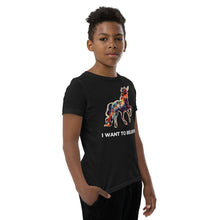 Load image into Gallery viewer, A photo of a young boy wearing an I Want To Believe t-shirt from Real Unicorn Apparel. 
