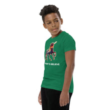 Load image into Gallery viewer, A side shot of a young boy in a Real Unicorn Apparel t-shirt. The tee is an I Want To Believe Youth Short Sleeve T-Shirt and has a multi-colored unicorn prominently displayed in the center of the shirt.
