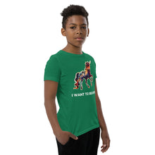 Load image into Gallery viewer, A boy looking straight ahead at the camera as he wears an I Want To Believe Youth Short Sleeve t-shirt from Real Unicorn Apparel.
