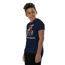 Load image into Gallery viewer, Side shot of a middle-schooler wearing a navy colored &quot;I Want To Believe&quot; t-shirt from Real Unicorn Apparel.
