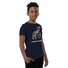 Load image into Gallery viewer, An African-American middle school boy wearing an &quot;I Want To Believe&quot; t-shirt that&#39;s made by Real Unicorn Apparel. The shirt has a unicorn drawn by artist Lauren Rubin.

