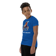 Load image into Gallery viewer, A calm-looking boy wearing a true royal I Want To Believe Youth Short Sleeve T-Shirt made by Real Unicorn Apparel, a quirky fashion brand.
