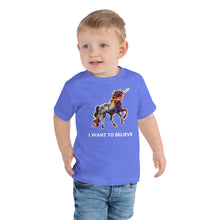 Load image into Gallery viewer, A toddler boy wearing a heather columbia blue-colored unicorn t-shirt from Real Unicorn Apparel. The shirt states &quot;I Want To Believe&quot; and features a multi-colored unicorn.
