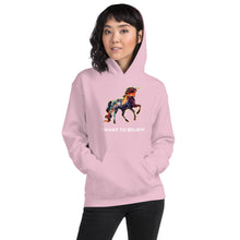 Load image into Gallery viewer, A gorgeously feminine light pink I Want To Believe Unisex Hoodie being modeled by a woman in her twenties. The hoodie is made by Real Unicorn Apparel and designed by co-founder and artist Lauren Rubin.
