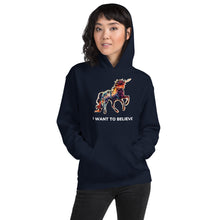 Load image into Gallery viewer, A model of East Asian descent wearing a navy hoodie from Real Unicorn Apparel&#39;s &quot;I Want To Believe&quot; collection. The hoodie has a gorgeously colorful unicorn on it.
